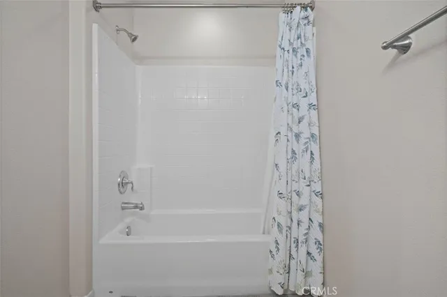 a bathroom with a shower curtain and a bath tub