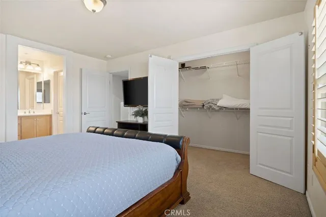 a bedroom with a bed and a flat tv screen in it