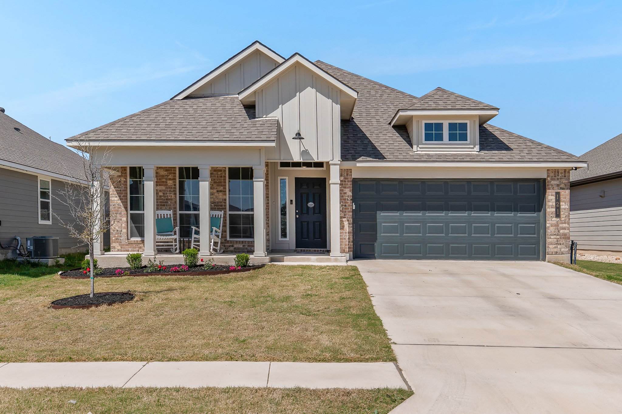 View of front of house featuring brick siding, board and batten siding, and a shingled roof