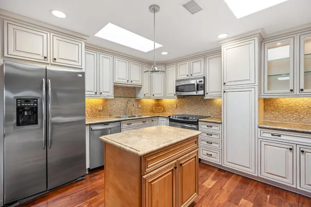 a kitchen with a refrigerator stove top oven and cabinets