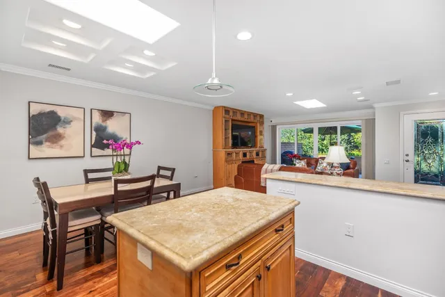 a view of a dining room with furniture a chandelier and wooden floor