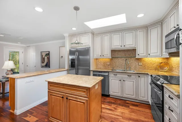 a kitchen with stainless steel appliances granite countertop a sink stove and refrigerator