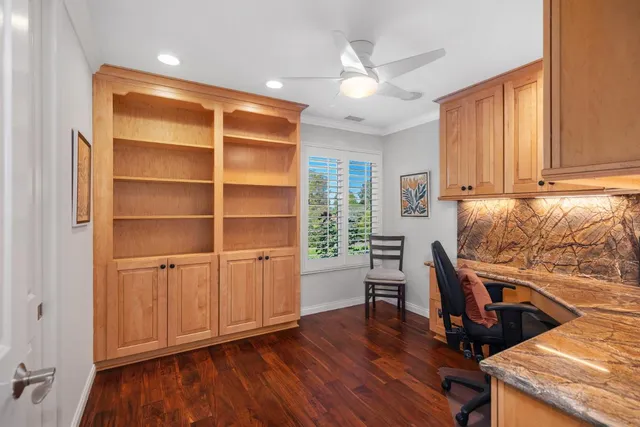 a view of a workspace with furniture and a window