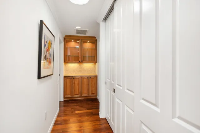 a view of a hallway with wooden floor and entryway