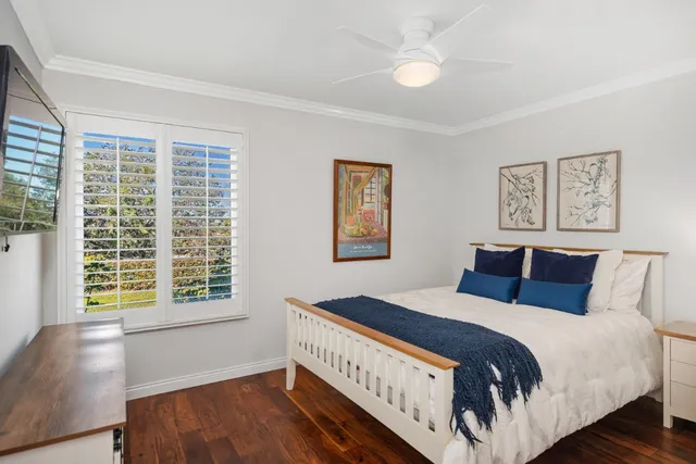 a large bedroom with a bed and wooden floor