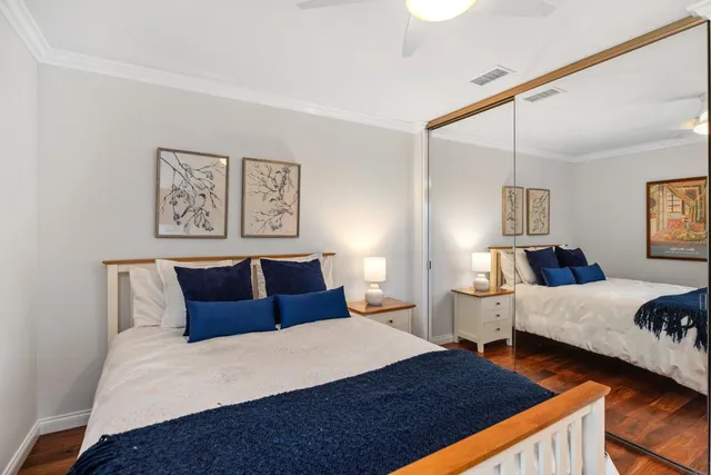 a bedroom with a bed and two large window