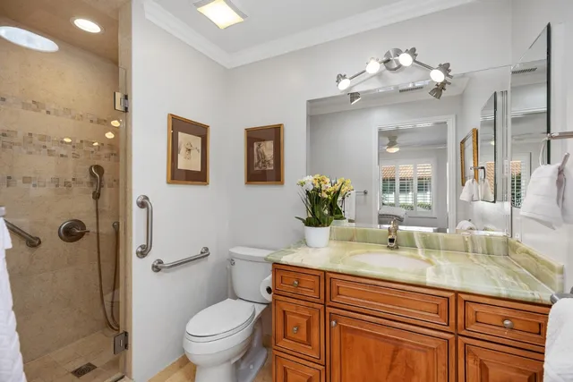 a bathroom with a granite countertop sink toilet and shower