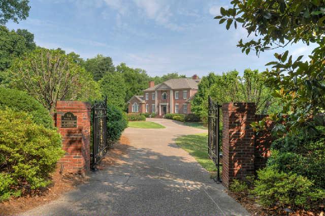 a view of house with a yard and potted plants