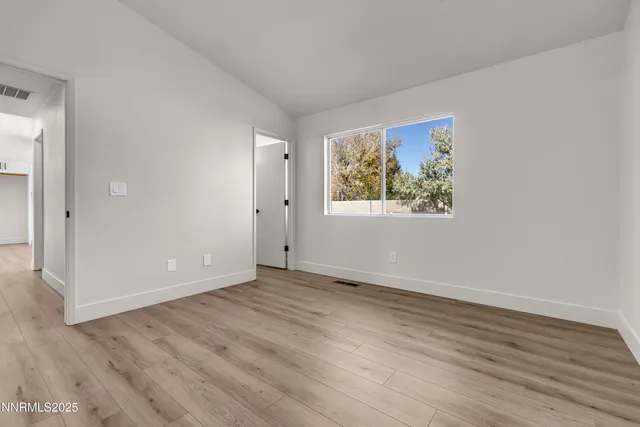 a view of an empty room with wooden floor