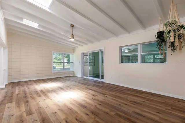 a view of empty room with wooden floor and fireplace