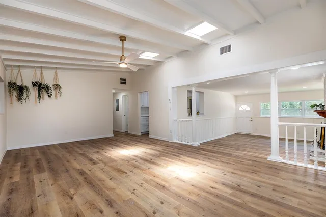 an empty room with windows and fireplace