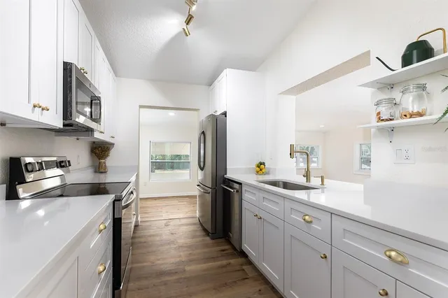 a kitchen with sink and white cabinets