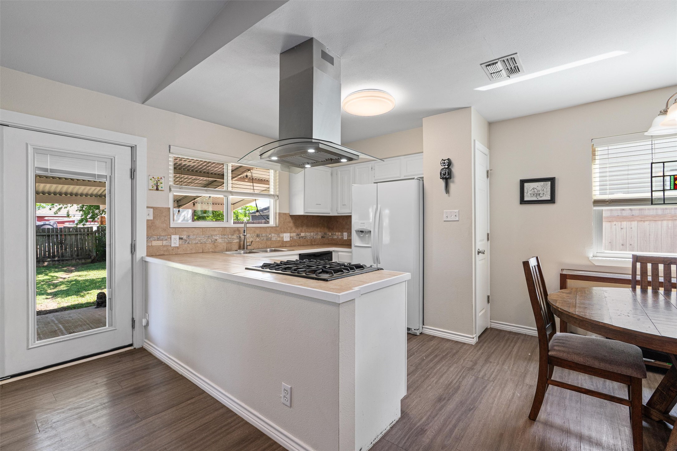 400 East Logan Street Round Rock, TX 78664 - Photo 9 of 25 a kitchen with a stove a refrigerator and wooden floor