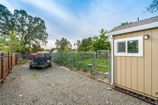 a view of a small yard in front of a house with large tree