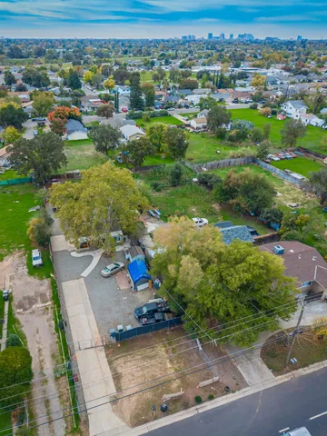 an aerial view of a city with lots of residential buildings ocean and mountain view in back