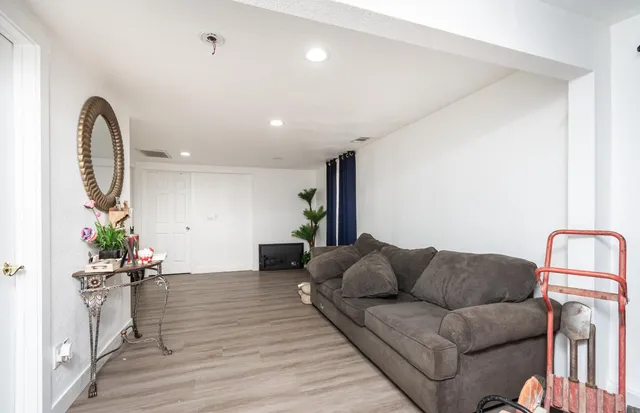 a living room with furniture a wooden floor and a grill