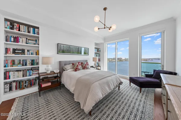a bedroom with a large bed and a chandelier