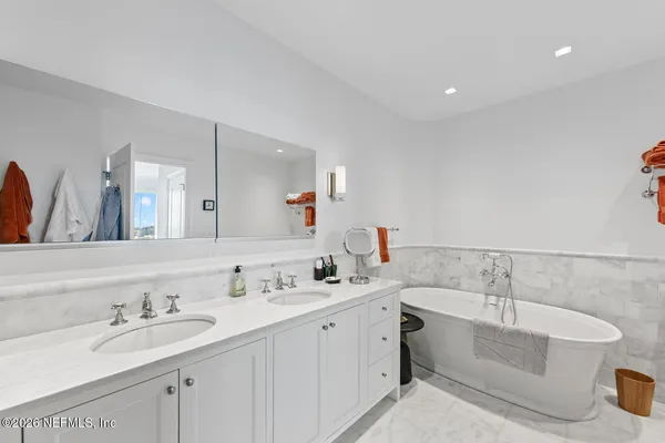 a bathroom with a double vanity sink a mirror and shower