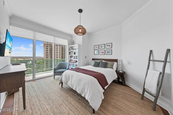 a bedroom with a large bed and a chandelier