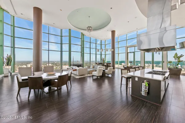 a dining room with furniture wooden floor and a floor to ceiling window