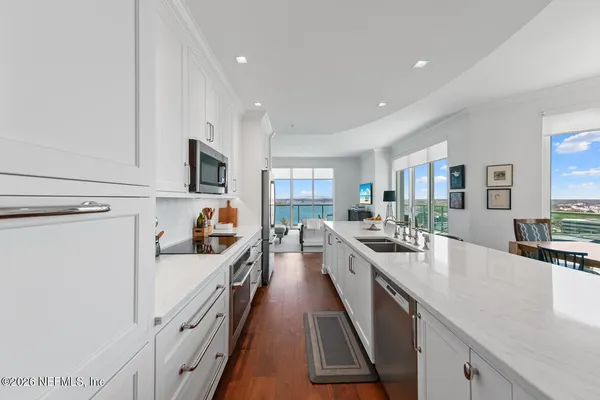 a kitchen with white cabinets and chairs