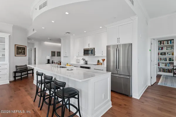 a large kitchen with stainless steel appliances granite countertop a lot of counter space and wooden floor