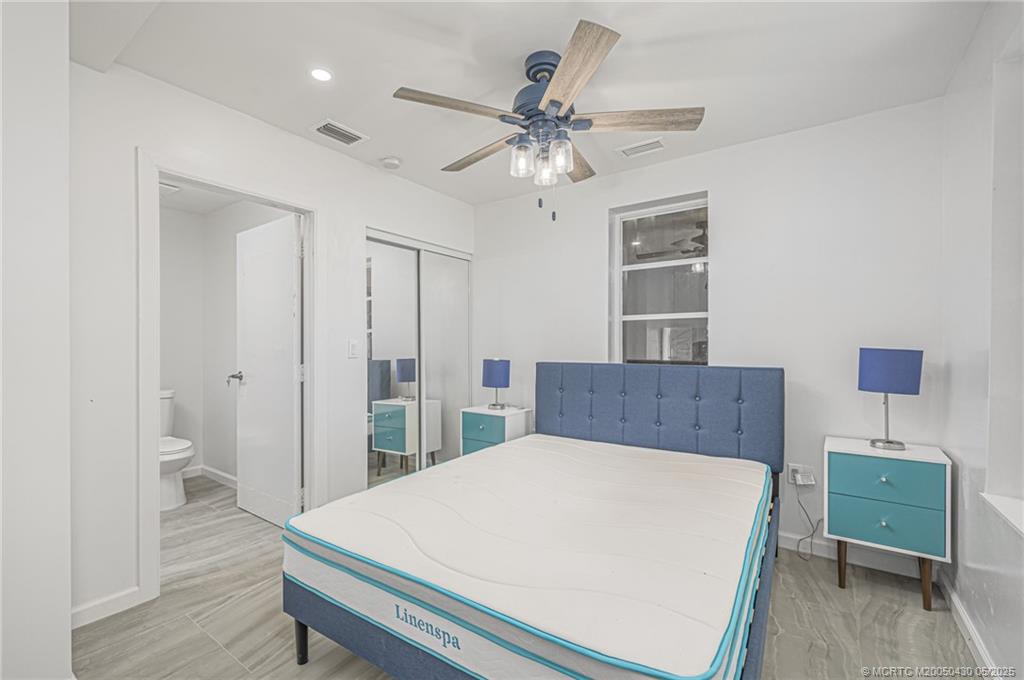 7007 South Indian River Drive Fort Pierce, FL 34982 - Photo 9 of 23 a bed room with a bed and a chandelier