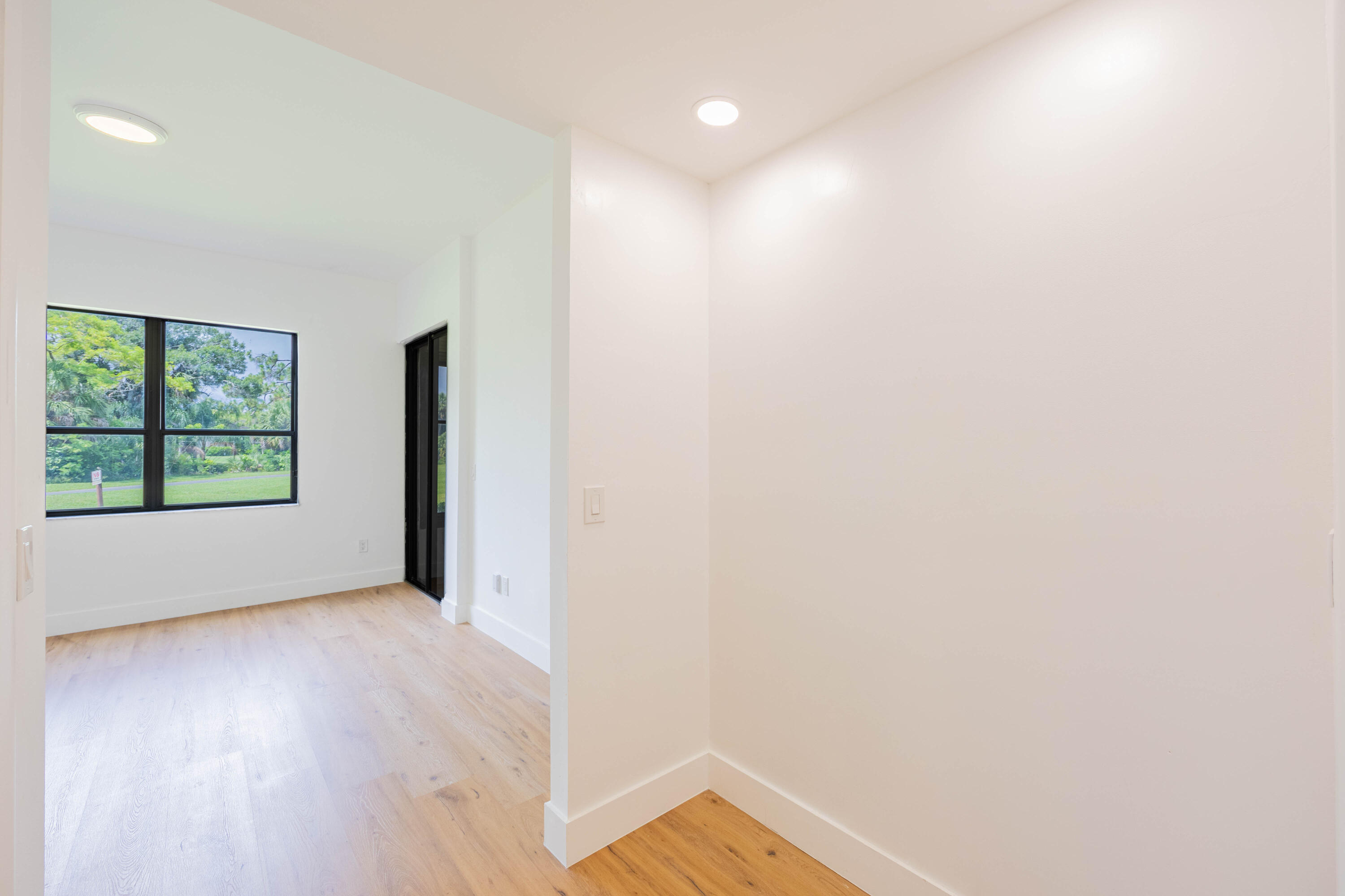 7520 La Paz Boulevard, Unit 104 Boca Raton, FL 33433 - Photo 27 of 56 a view of an empty room with wooden floor and a window