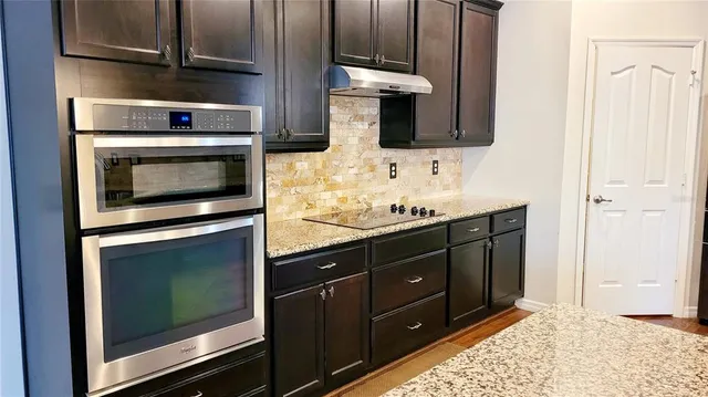 a kitchen with stainless steel appliances kitchen island granite countertop a stove and a microwave