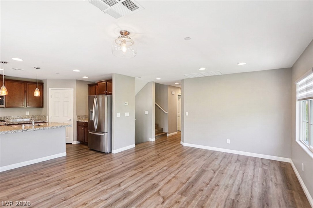 9940 Sable Point Street Las Vegas, NV 89178 - Photo 40 of 40 Kitchen with stainless steel refrigerator with ice dispenser, open floor plan, light wood-style flooring, baseboards, and recessed lighting