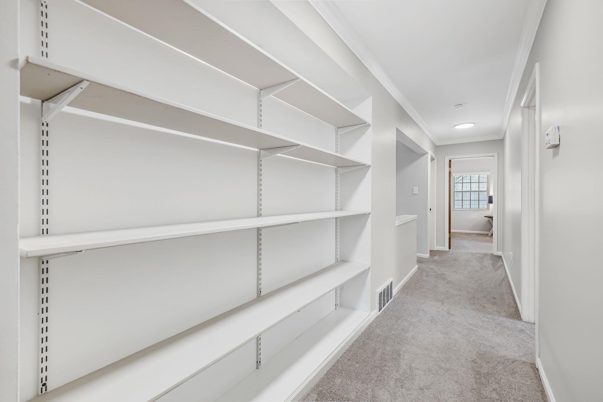 4729 Cedar Ridge Drive Millington, TN 38053 - Photo 31 of 40 Hallway featuring extensive adjustable shelving, soft gray carpeting, white crown molding, and recessed lighting