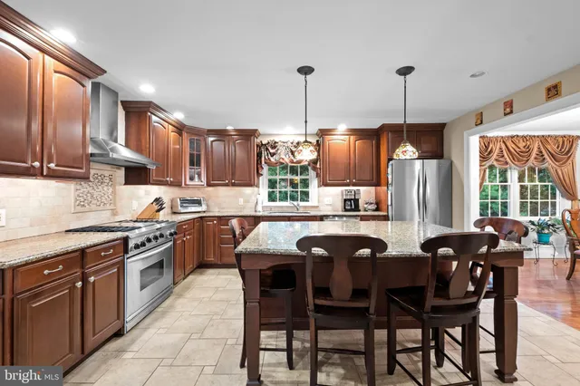 a kitchen with stainless steel appliances granite countertop wooden cabinets a stove a sink dishwasher and a wooden cabinets