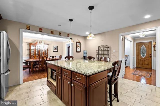 a large kitchen with stainless steel appliances granite countertop a sink a stove and a refrigerator