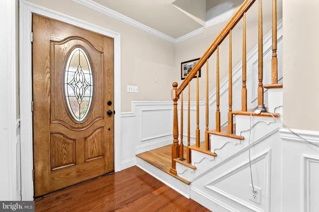 a view of front door with wooden floor and a potted plant