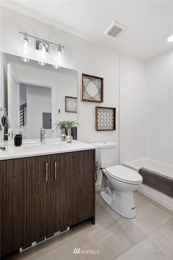 1324 East Spring Street Seattle, WA 98122 - Photo 5 of 29 a bathroom with a sink vanity mirror and toilet