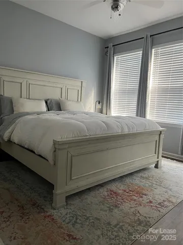 a bedroom with a bed and windows