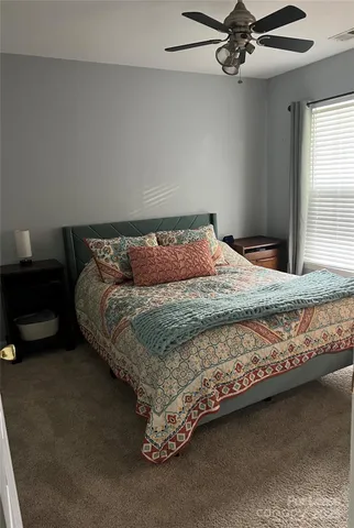 a bedroom with a bed and ceiling fan