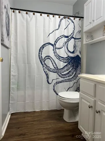 a bathroom with a toilet and a shower curtain