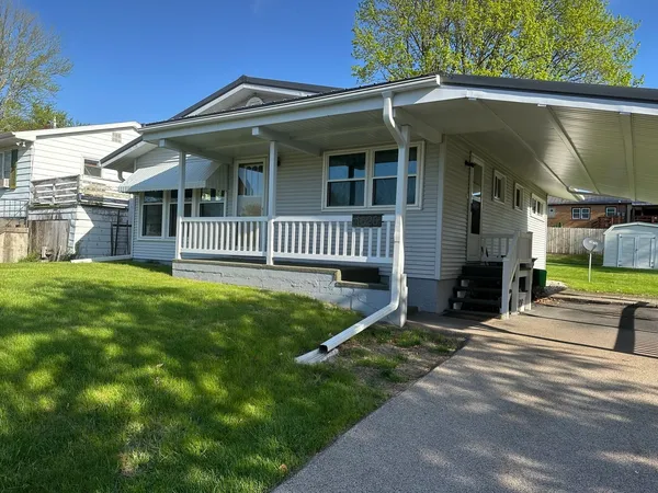 a view of a house with a yard and porch