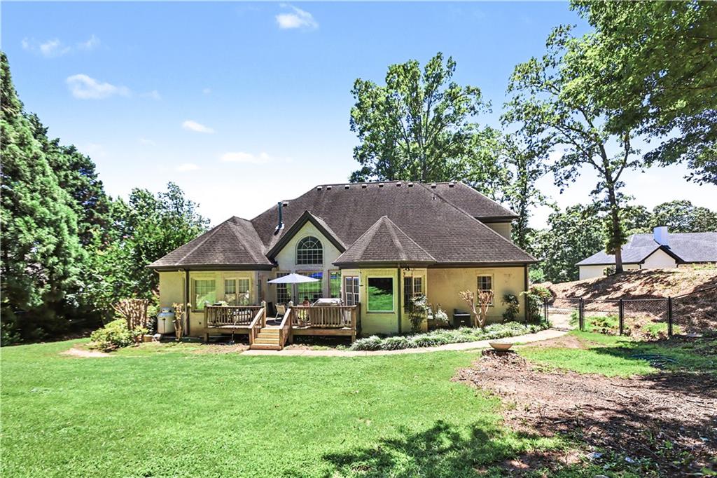 537 Old Collins Road Hoschton, GA 30548 - Photo 35 of 42 a patio with a table and chairs under an umbrella