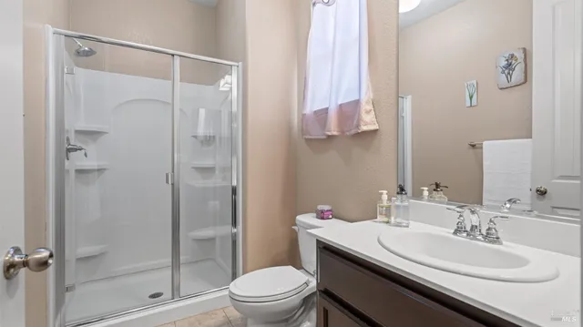 a bathroom with a granite countertop sink toilet a mirror a vanity and shower