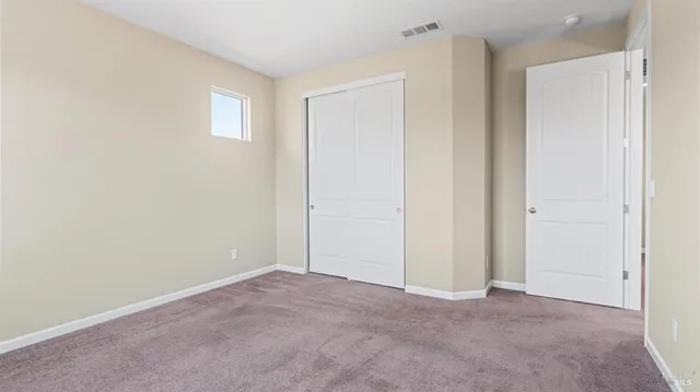 a view of an empty room and closet area