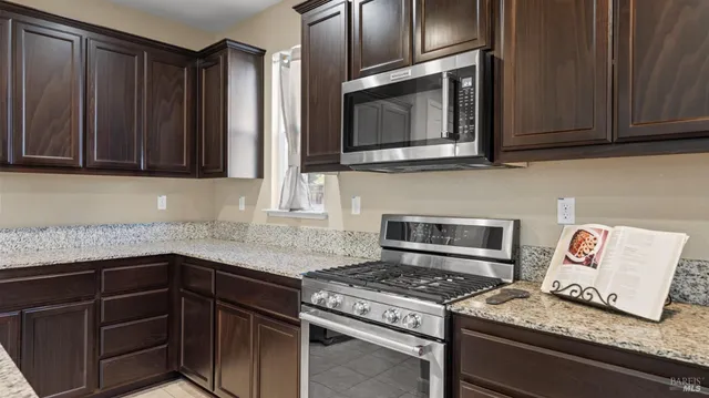 a kitchen with granite countertop cabinets and steel stainless steel appliances