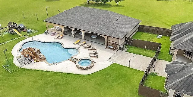 an aerial view of a house with garden space and swimming pool
