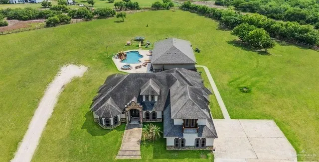 an aerial view of a house with a yard basket ball court and outdoor seating