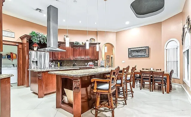 a kitchen with stainless steel appliances granite countertop a table and chairs in it