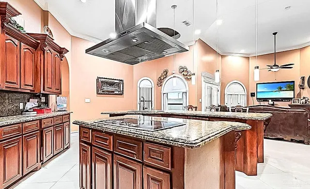 a kitchen with stainless steel appliances granite countertop a sink stove and cabinets