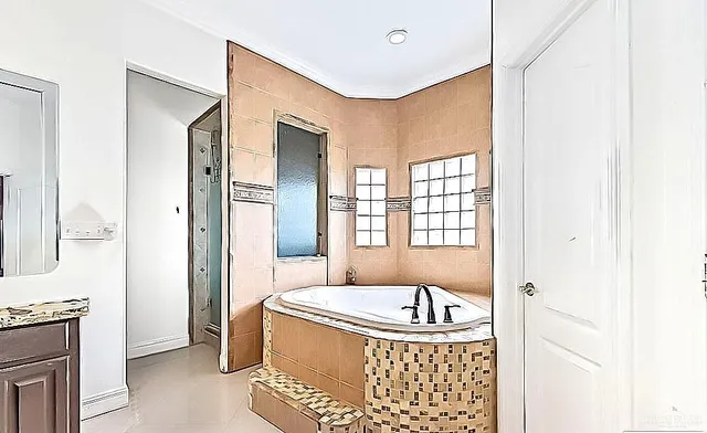 a bathroom with a tub shower and window
