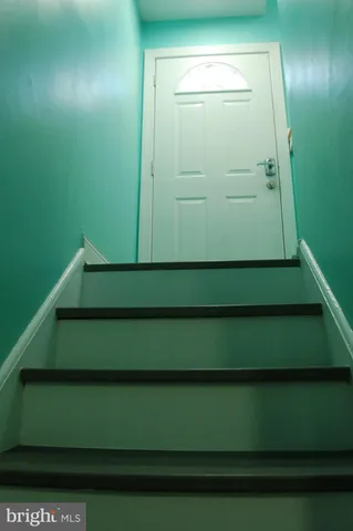 a view of a hallway to a kitchen with washer and dryer