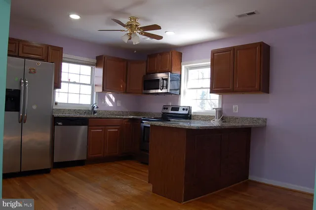 a kitchen with granite countertop a sink cabinets and stainless steel appliances